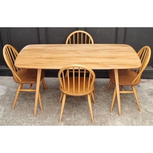 1073 - A mid-century Ercol blonde dining suite, comprising: a Windsor table, 152cm long; and a set of six '... 