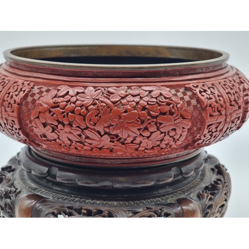 1392 - An unusual Chinese cinnabar lacquer and cloisonne enamel bowl, 24.5cm diameter, on good carved and p... 