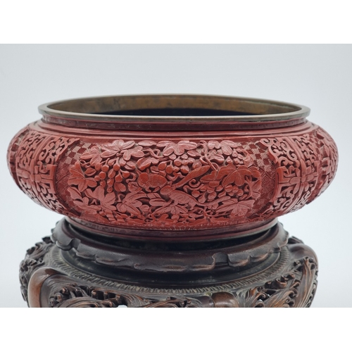 1392 - An unusual Chinese cinnabar lacquer and cloisonne enamel bowl, 24.5cm diameter, on good carved and p... 