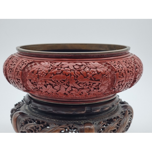 1392 - An unusual Chinese cinnabar lacquer and cloisonne enamel bowl, 24.5cm diameter, on good carved and p... 