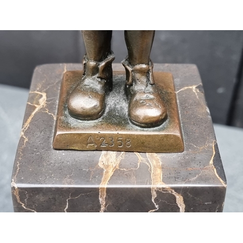 1565 - A bronze figure of a young boy, inscribed 'ManGreB', on marble socle, 28.5cm high.