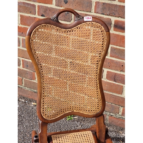 1064 - A small Victorian walnut and cane folding chair.