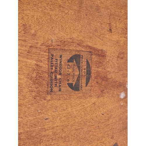 1075 - A rare pair of 1940s Ercol Windsor chairs, one labelled 'B.O.T., Price-Control Mark, Max. Price £2:7... 