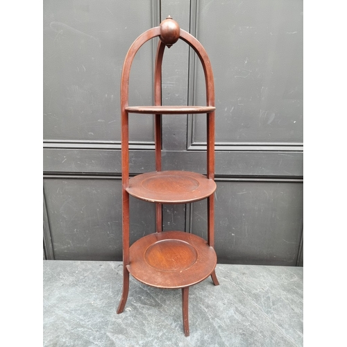 1116 - A late Edwardian mahogany three-tier cake stand, 88cm high.