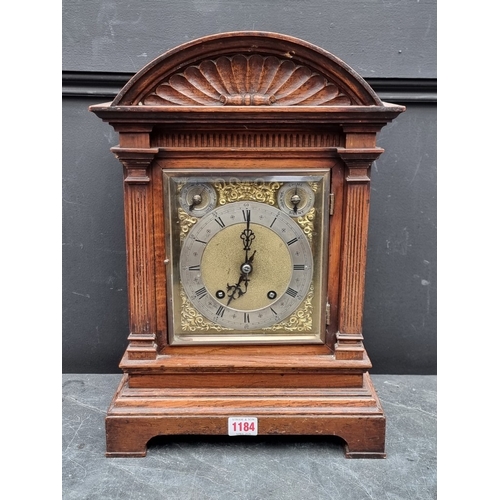 1184 - A late 19th century carved oak mantel clock, 44cm high, with pendulum.