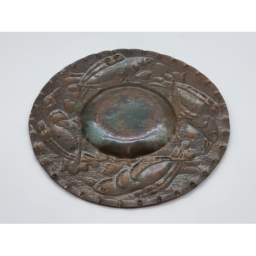 1554 - An Arts & Crafts style embossed copper dish, 21.5cm diameter.