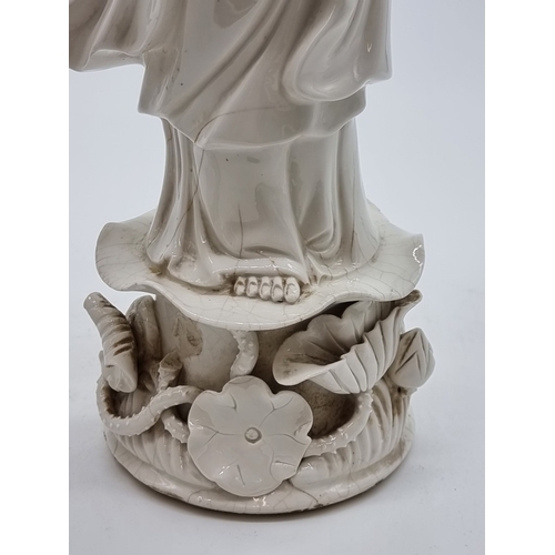 1571 - Three Chinese blanc de chine figures of Guanyin, largest 40.5cm high, (s.d. to each).... 