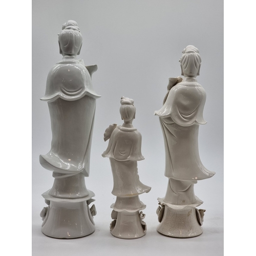 1571 - Three Chinese blanc de chine figures of Guanyin, largest 40.5cm high, (s.d. to each).... 