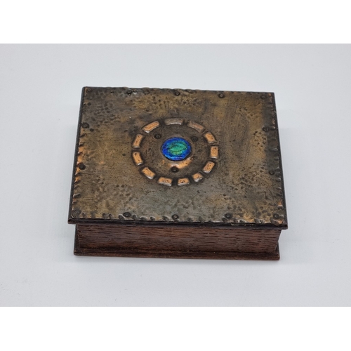 1585 - An Arts & Crafts style oak, copper and enamel casket, 11.5cm wide; together with a copper and br... 