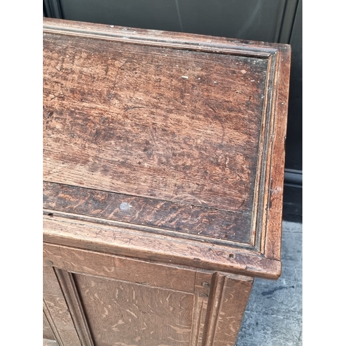 1111 - A late 17th century oak panelled coffer, 114cm wide, (wormed); together with another oak side cabine... 