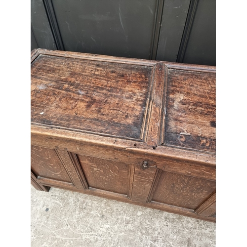 1111 - A late 17th century oak panelled coffer, 114cm wide, (wormed); together with another oak side cabine... 