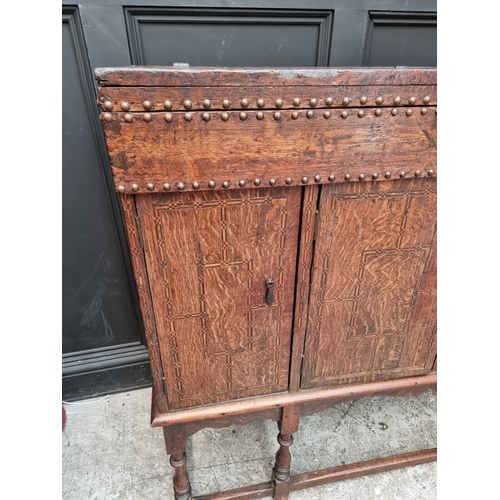 1111 - A late 17th century oak panelled coffer, 114cm wide, (wormed); together with another oak side cabine... 