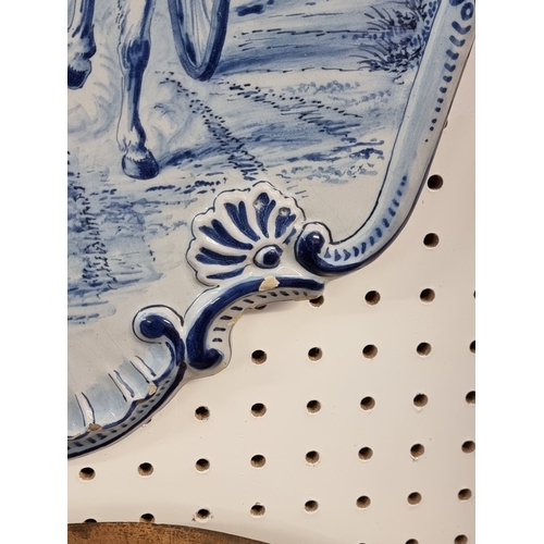 1674 - A pair of 19th century Dutch Delft wall plaques, each painted with a pony and trap, 55 x 40cm.... 