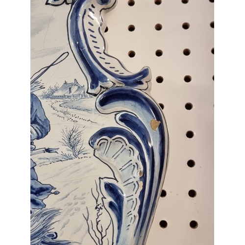 1674 - A pair of 19th century Dutch Delft wall plaques, each painted with a pony and trap, 55 x 40cm.... 