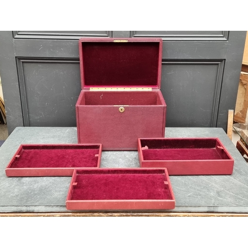 1677 - An interesting and impressive dark red leather jewellery chest, the hinged top applied with gilt bra... 