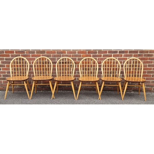 1073 - A mid-century Ercol blonde dining suite, comprising: a Windsor table, 152cm long; and a set of six '... 