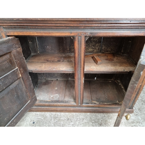 1003 - An 18th century oak panelled cupboard, 76.5cm high x 95.5cm wide, (alterations).