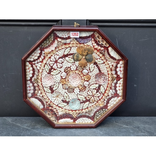 A reproduction mahogany framed octagonal shell panel, in the style of a ...