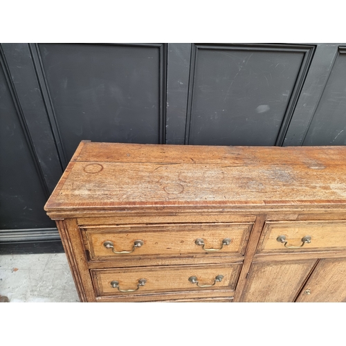 1051 - A George III oak, walnut crossbanded and line inlaid dresser base, 187cm wide.
