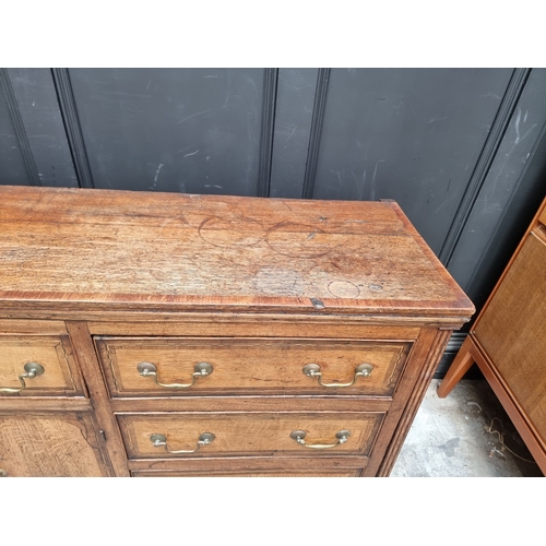 1051 - A George III oak, walnut crossbanded and line inlaid dresser base, 187cm wide.