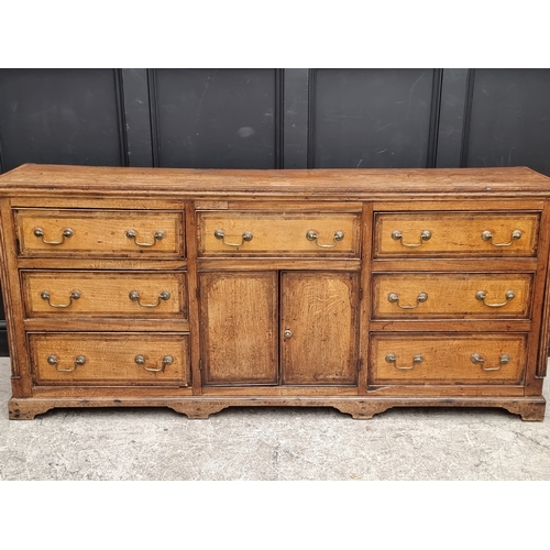 1051 - A George III oak, walnut crossbanded and line inlaid dresser base, 187cm wide.