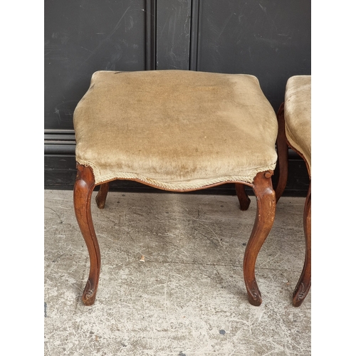 1056 - A pair of late 19th century walnut and upholstered stools.