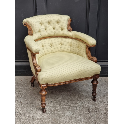 1059 - A late Victorian carved oak and button upholstered tub chair.
