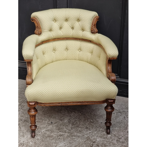 1059 - A late Victorian carved oak and button upholstered tub chair.