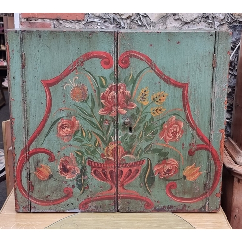 1003 - An antique green and floral painted cabinet, 58.5cm high x 67cm wide.