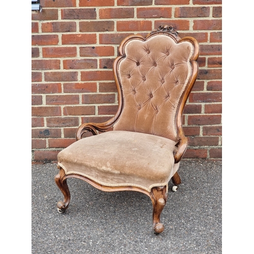 1054 - A Victorian carved walnut and button upholstered occasional chair.
