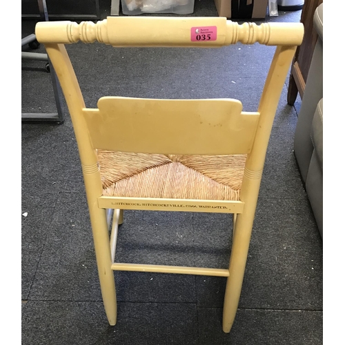 35 - VERY UNUSUAL AMERICAN CREAM COLOURED EBONISED CHAIR WITH RATTAN SEAT AND AND ORNATE DETAILING TO BAC... 