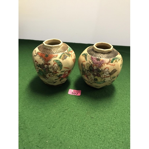 402 - PAIR OF ORIENTAL POTS - AGE UNKNOWN - MARKS TO BASE - DEPICTING SAMURI FIGHTING - 14CMS H