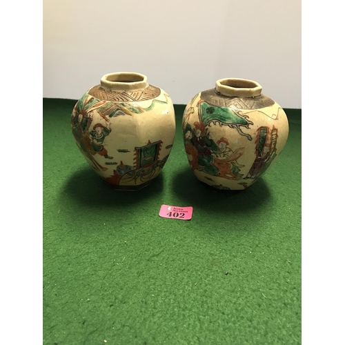 402 - PAIR OF ORIENTAL POTS - AGE UNKNOWN - MARKS TO BASE - DEPICTING SAMURI FIGHTING - 14CMS H