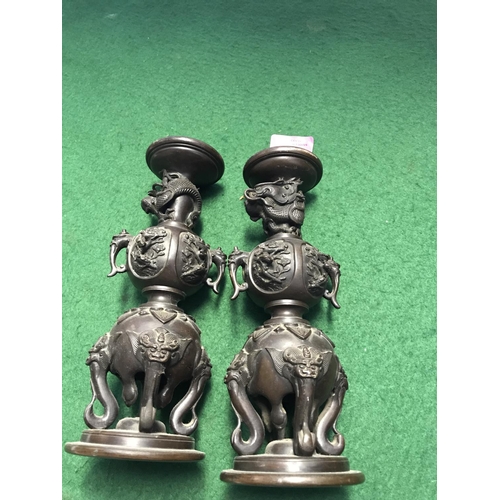 372 - PAIR OF EARLY BRONZE EASTERN STYLE CANDLESTICKS DECORATED WITH ELEPHANTS & DRAGONS - 23CMS H