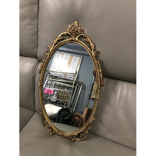 572 - OVAL SHAPED GILT FRAMED MIRROR - 30CMS X 50CMS