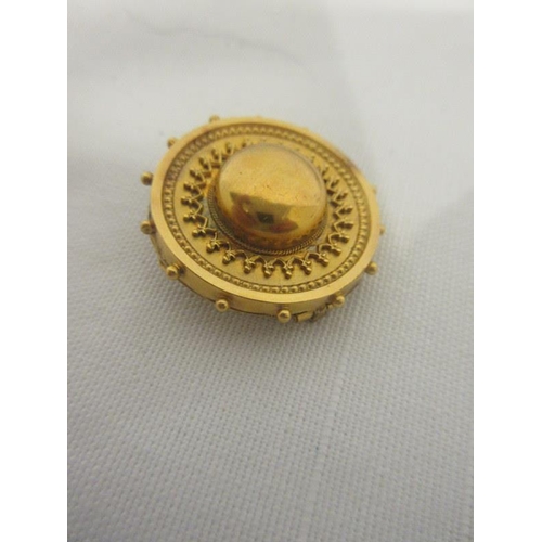 171 - A 15 carat gold circular shield shaped antique brooch, the reverse inset with a lock of hair.