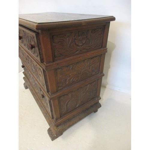 215 - An unusual antique carved oak chest of two short and two long drawers and raised on scroll feet. W. ... 