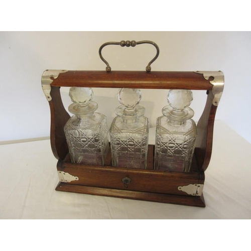 68 - Antique mahogany cased tantalus with three cut glass decanters and plated mounts.