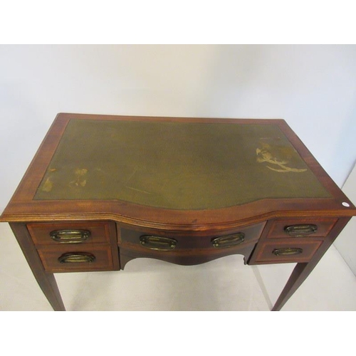 120 - An Edwardian mahogany bow shaped writing desk fitted with eight drawers and raised on tapered legs. ... 