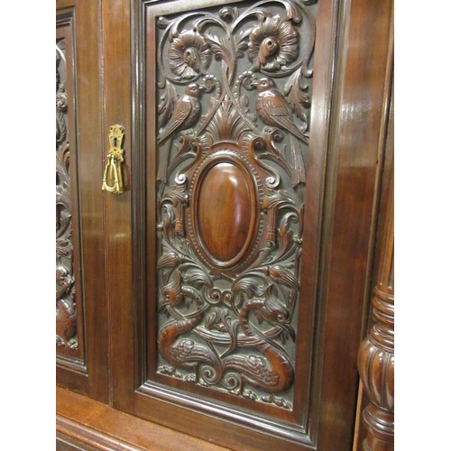 100 - A good antique 19th century wardrobe having light and dark walnut panels with carved decoration, the... 