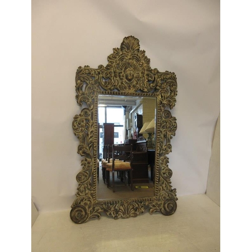 132 - A large decorative carved wood mirror with bevelled glass plate. H. 205cm, W. 124cm approx.