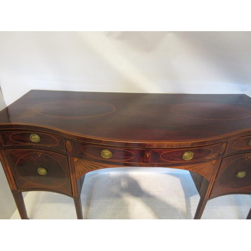 135 - A fine Irish Georgian sideboard, the serpentine shaped top having inlaid oval panels, the freize fit... 