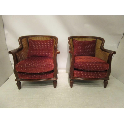 54 - A good pair of French mahogany bergere drawing room chairs and cushions raised on turned legs. W. 65... 