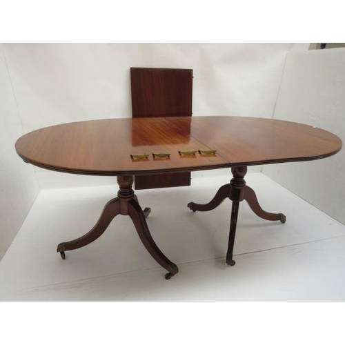 61 - A Regency style mahogany twin pod dining table with spare leaf probably O'Connell's Cork.