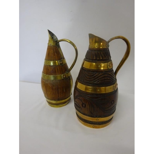 50 - Two oak and brass bound timber jugs. H. 24cm approx.