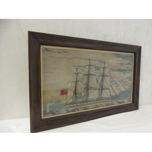 59 - Old wool work picture of a British sailing ship passing a lighthouse. 29cm x 50cm approx.