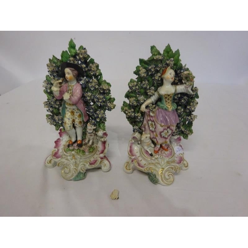 132 - A pair of flower encrusted porcelain figures.