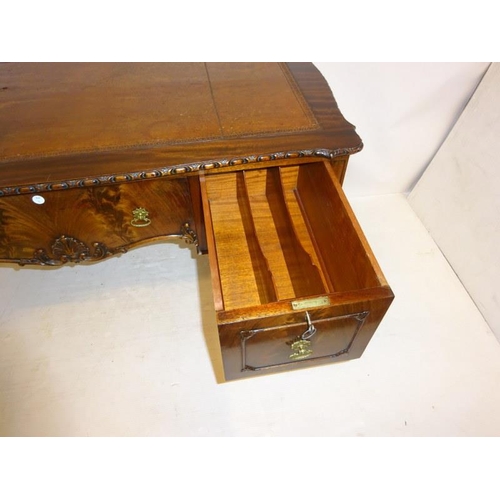 140 - A fine Edwardian mahogany desk, the shaped rectangular top having tooled leather inset, fitted with ... 