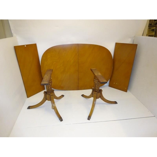 176 - An American D shaped dining table having two spare leaves and raised on twin pods. (some re-polishin... 