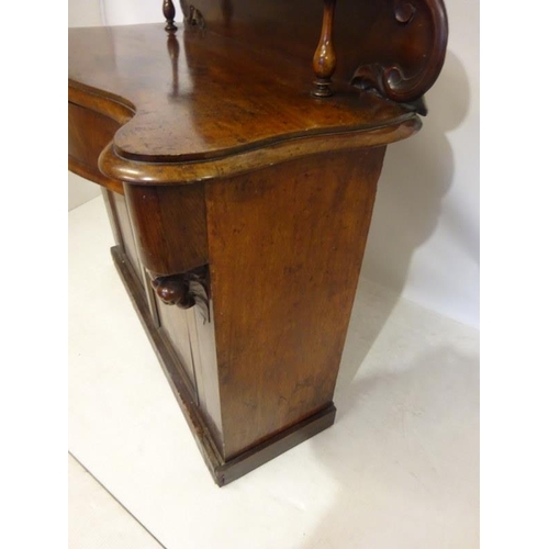 194 - Victorian mahogany side cabinet having carved back with shelf, serpentine shaped drawer over two doo... 